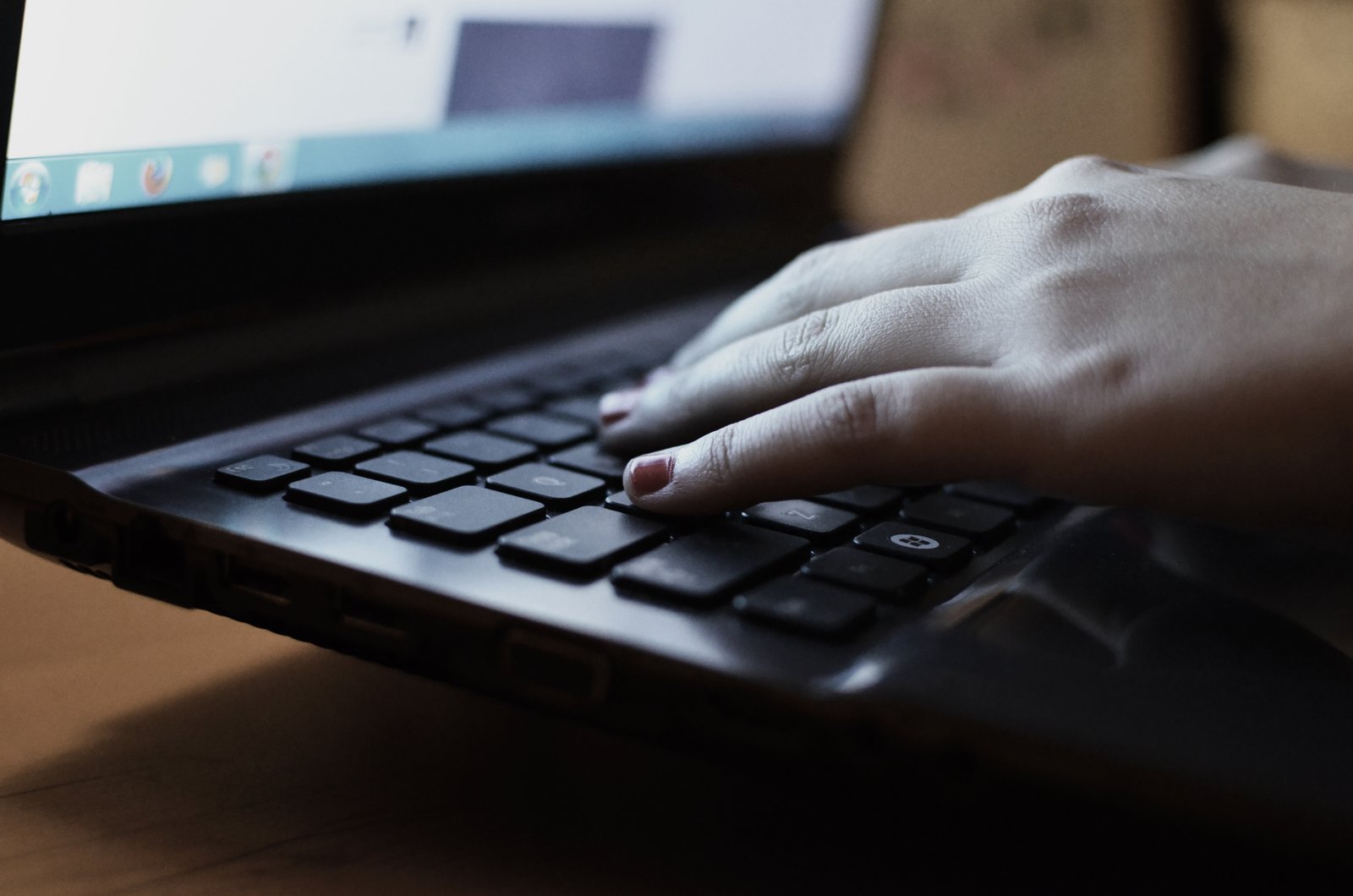 Hands typing on a laptop and notebook at a desk, representing organized insurance and claims administrative support