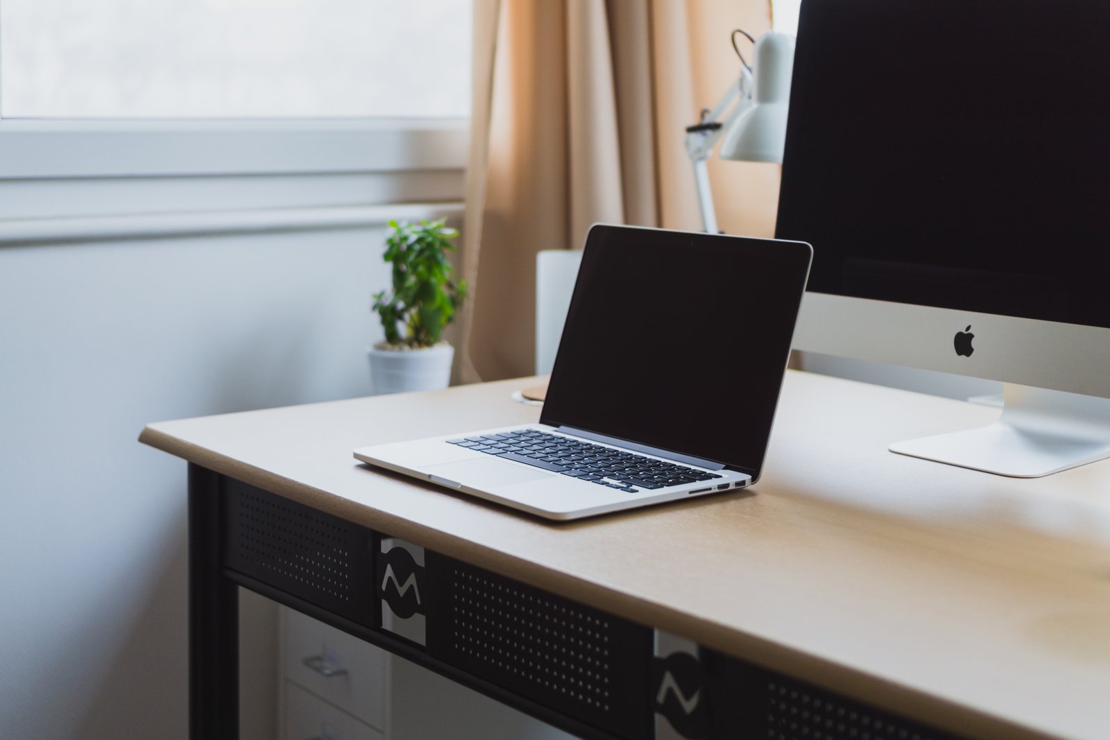 Neatly organized laptop and desk workspace, representing structured business and administrative support